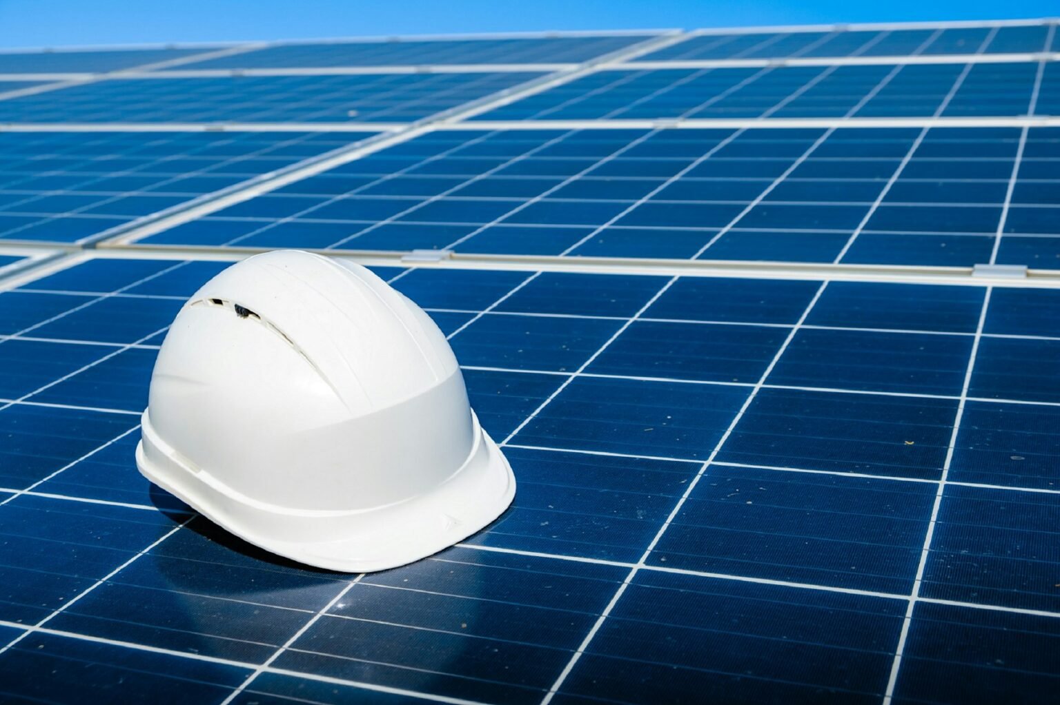 Capacete de segurança sobre módulos fotovoltaicos