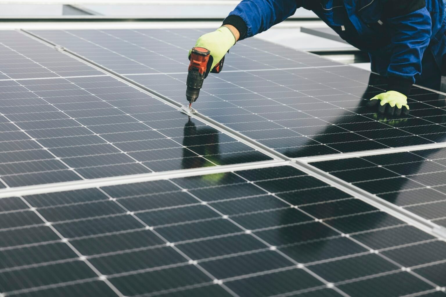 Técnico fixando módulos fotovoltaicos em cobertura