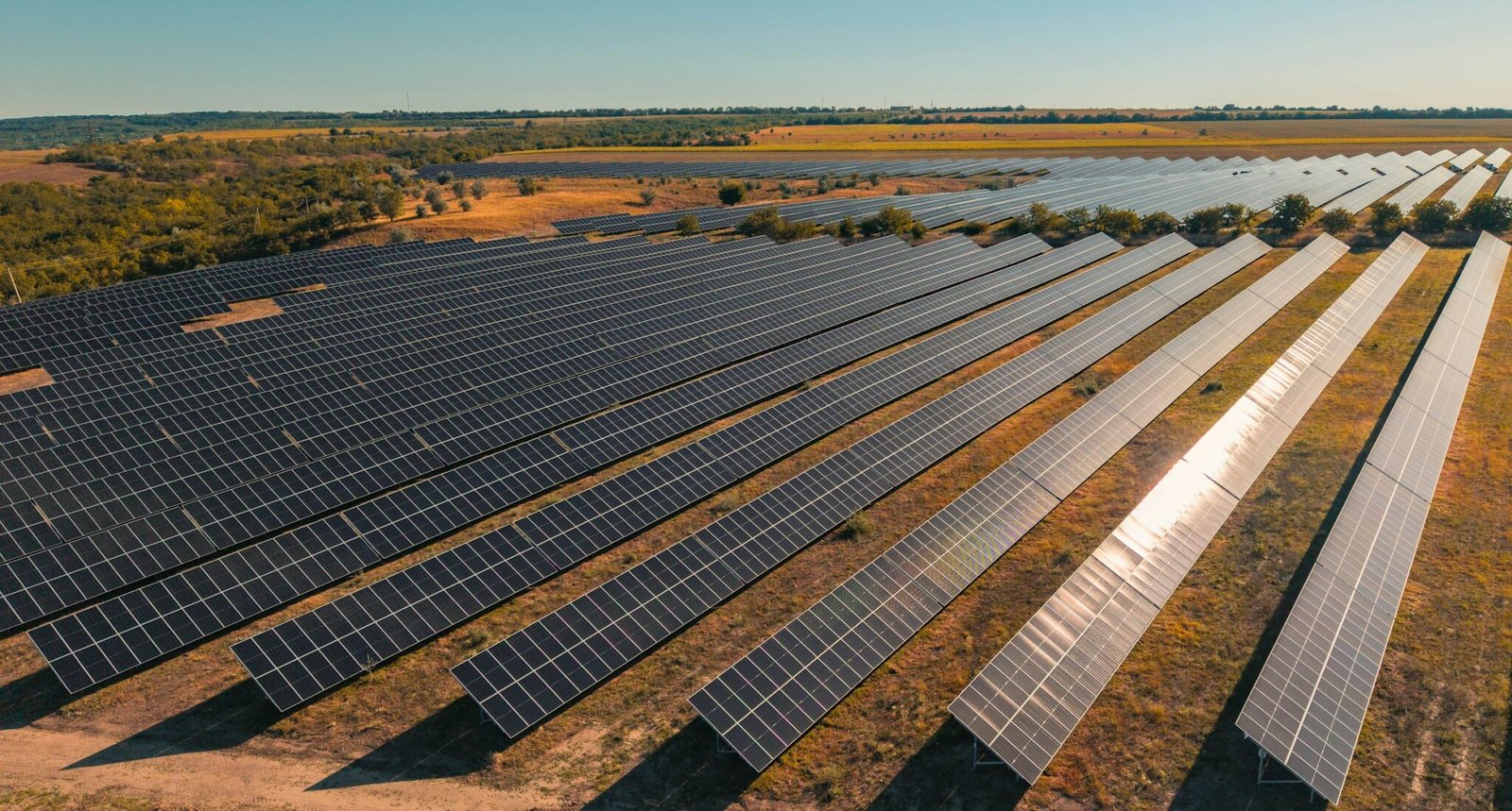 Vista aérea de usina solar de grande porte ao entardecer